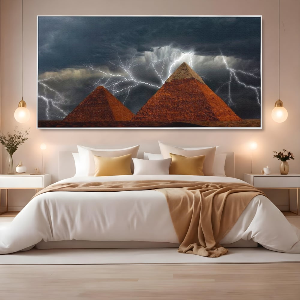 Tablou canvas cu ilustratie cu piramide si fulgere, in rama de aluminiu argintiu, pe perete intr-un dormitor